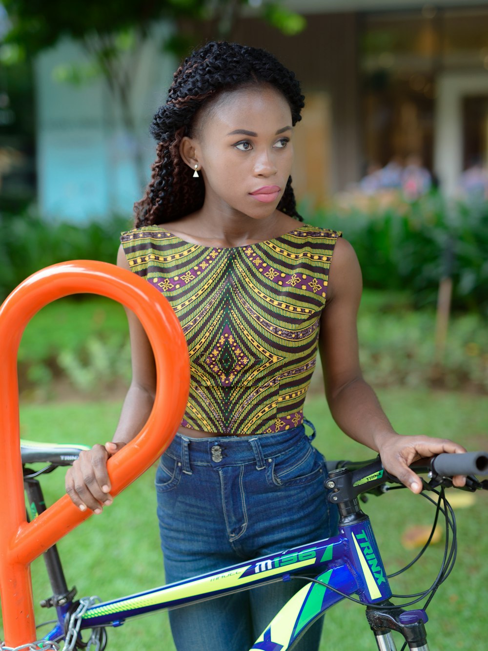 girl in green and black tank top and blue denim shorts holding orange metal bar during