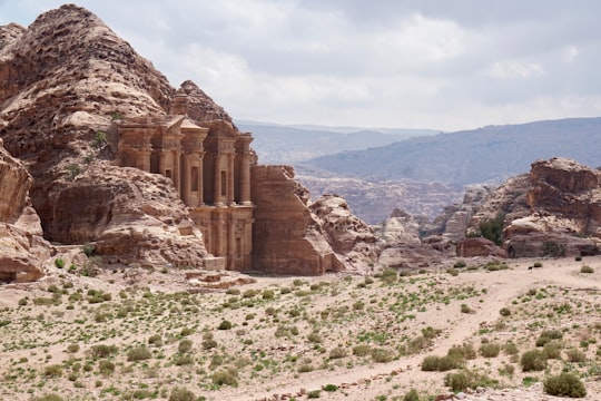 brown rock formation under white clouds during daytime in Petra Jordan