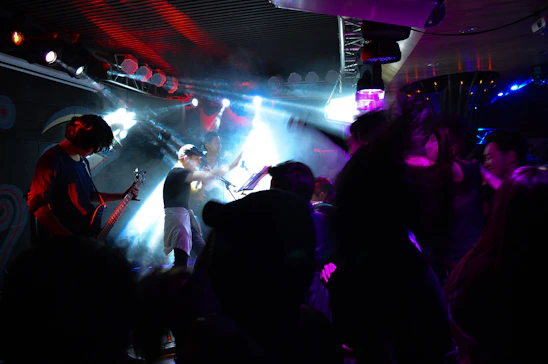 A lively concert scene with musicians passionately playing on stage under colorful lights.
