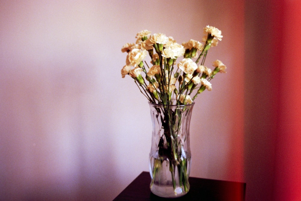 yellow flowers in clear glass vase