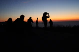Sunset view from a photographic trip, with travelers capturing the moment on analog cameras.