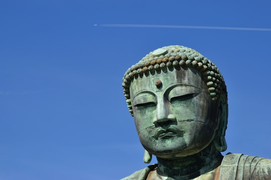 gray concrete statue under blue sky during daytime in Kōtoku-in Japan