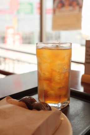 A refreshing cup of Secaps Black Chá served with ice cubes on a sunny kitchen table
