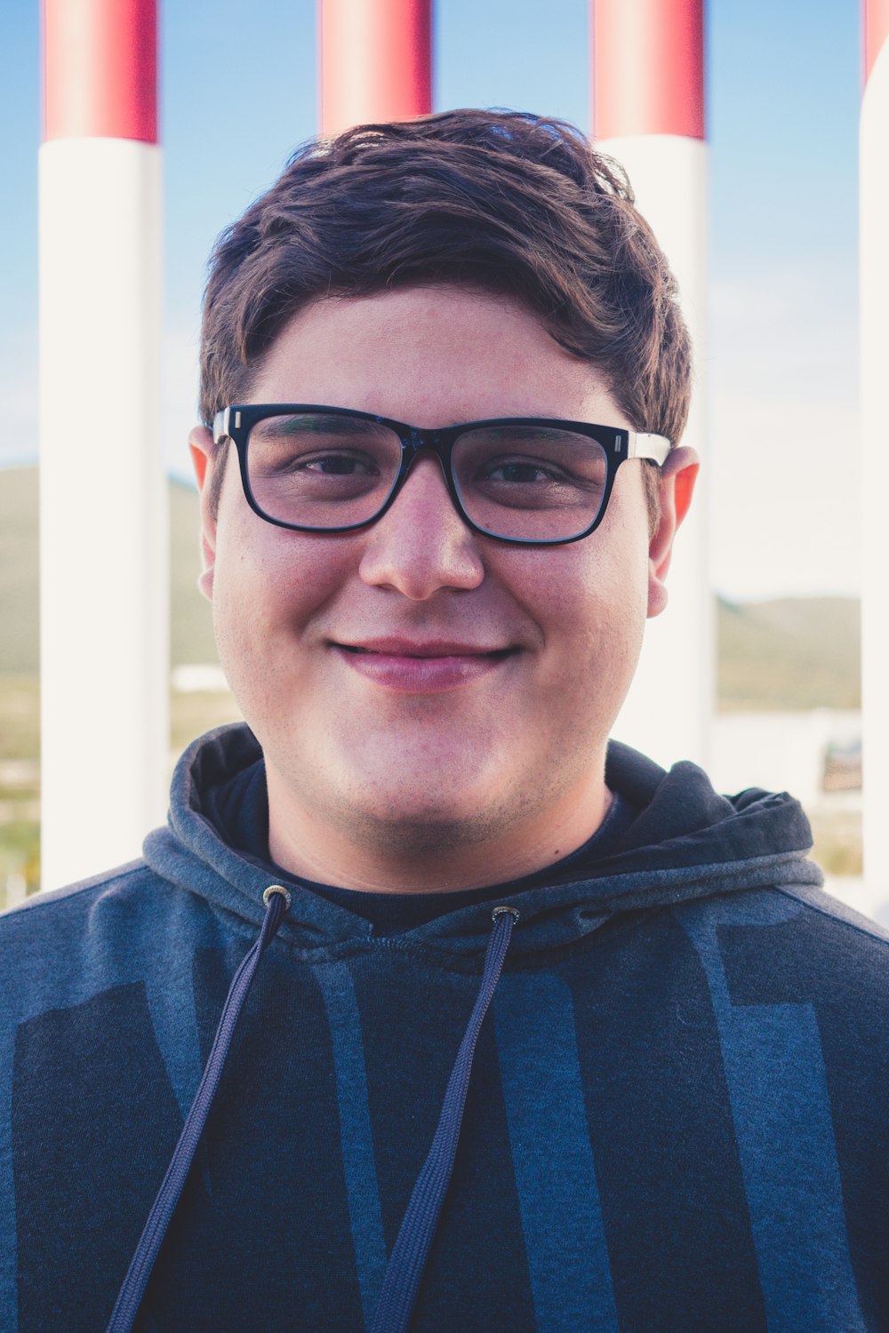 man in blue and gray hoodie wearing black framed eyeglasses