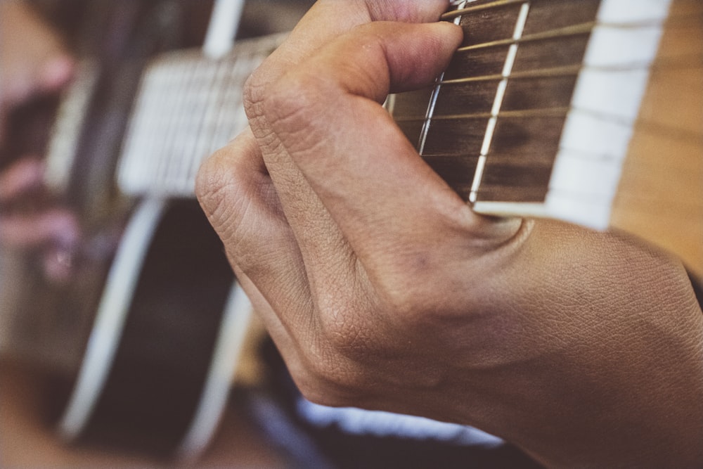 Persona che suona la chitarra nella fotografia in scala di grigi