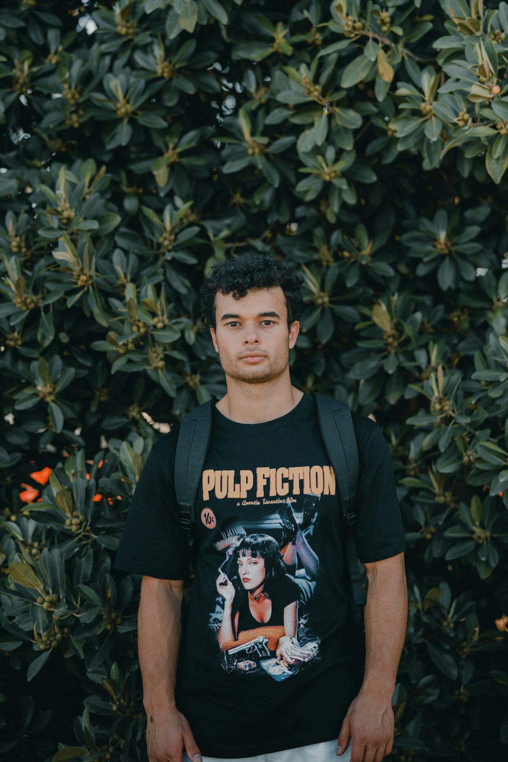 man in black crew neck t-shirt standing near green plants during daytime