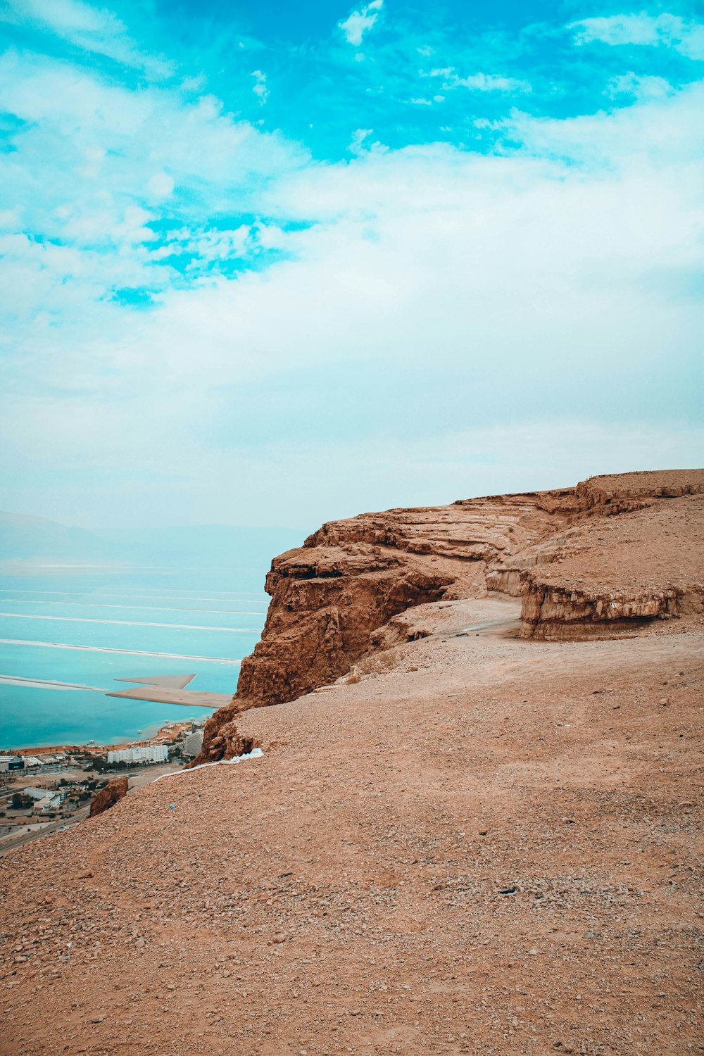 brown rocky mountain near body of water during daytime