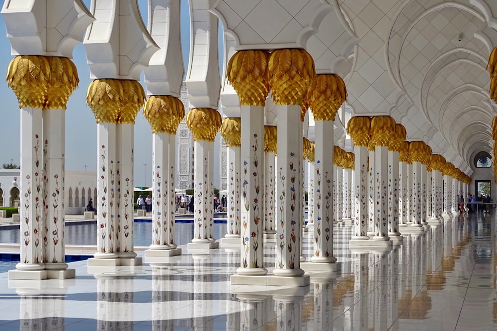 a row of white and gold pillars in a building