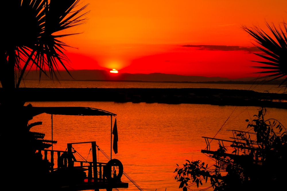 silhouette of people on boat on sea during sunset