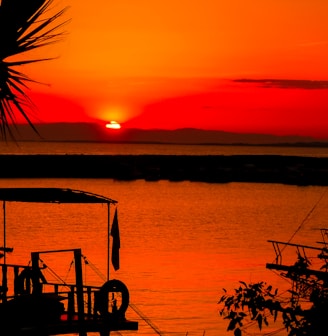 silhouette of people on boat on sea during sunset