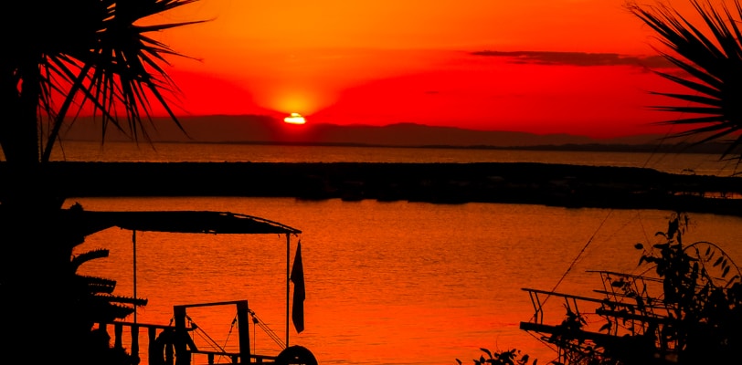 silhouette of people on boat on sea during sunset