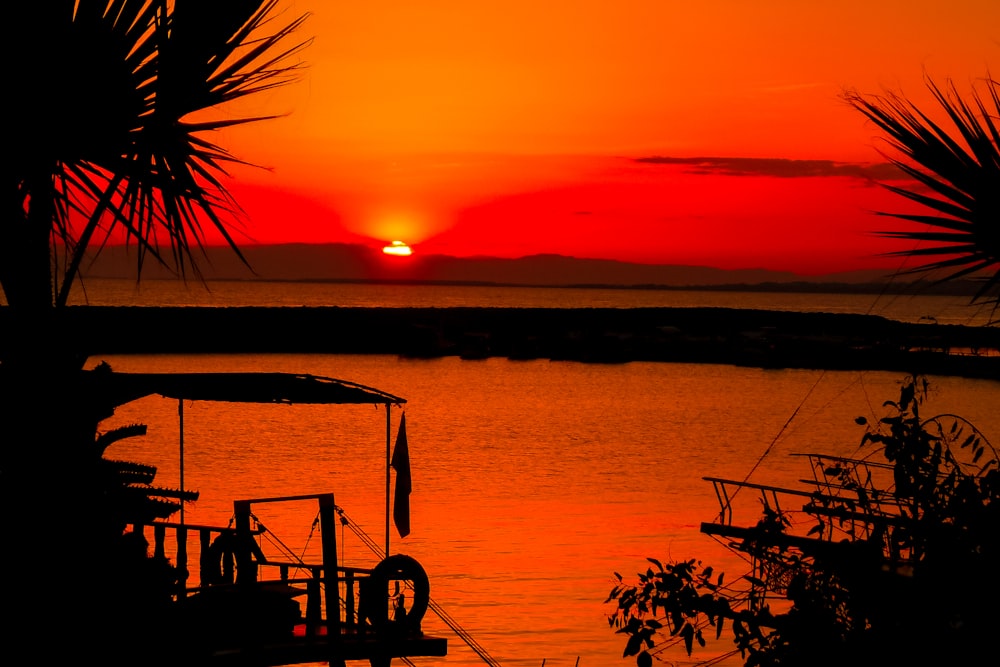 Silhouette von Menschen auf dem Boot auf See während des Sonnenuntergangs