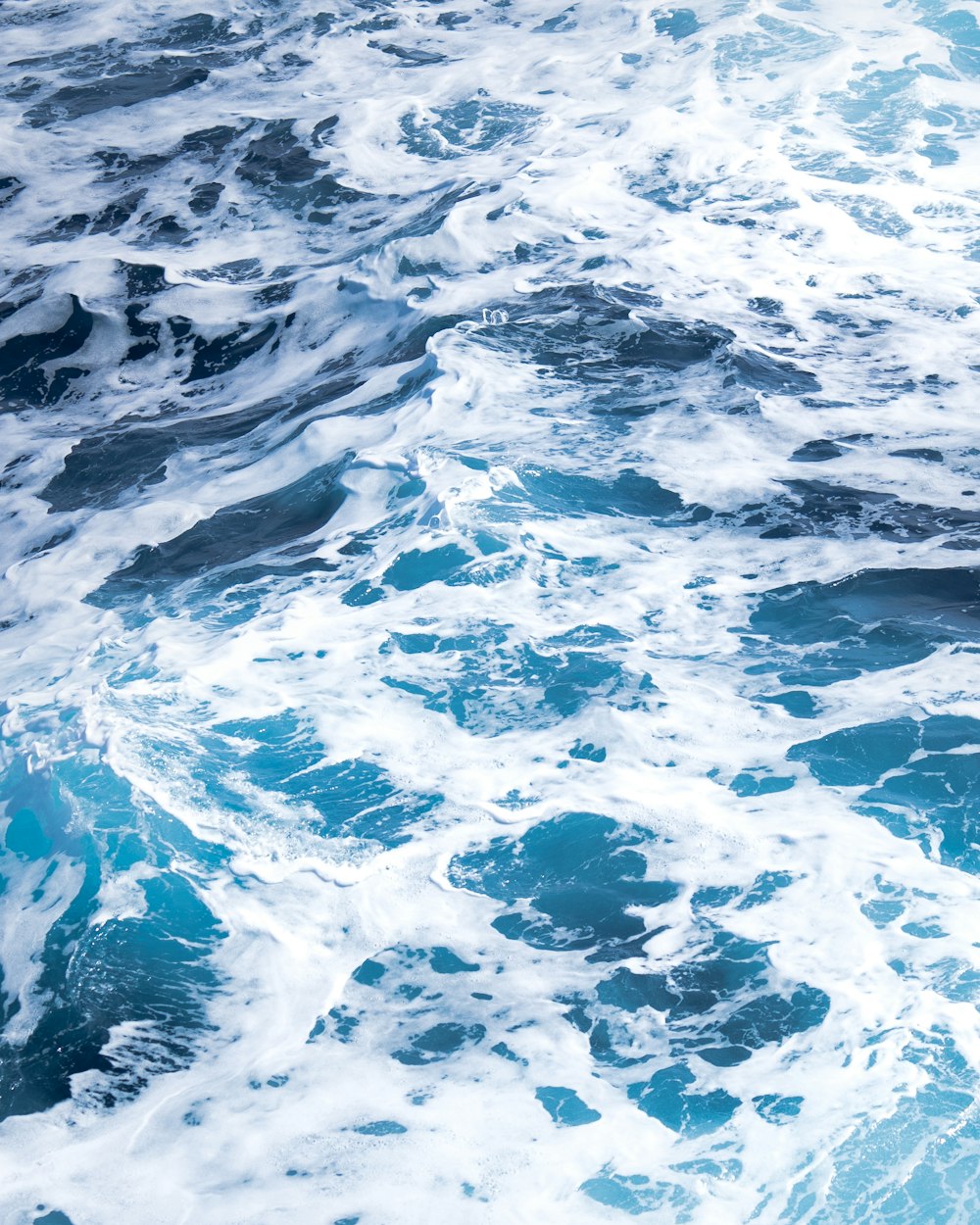 water waves on blue body of water during daytime