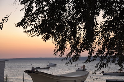A scenic view of fishing boats on the water at sunset.