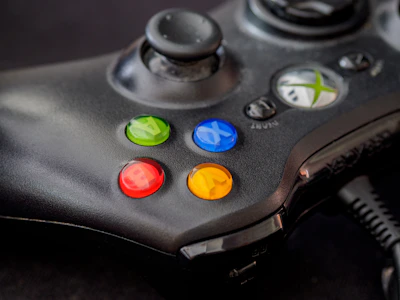 black xbox game controller with green orange yellow and red buttons
