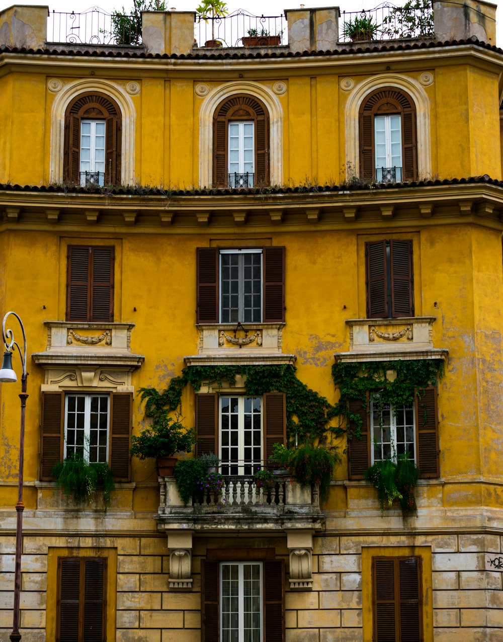 Bâtiment en béton jaune avec des arbres verts devant