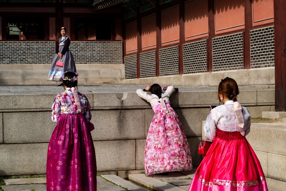 2 girls in white and pink dresses standing on gray concrete stairs