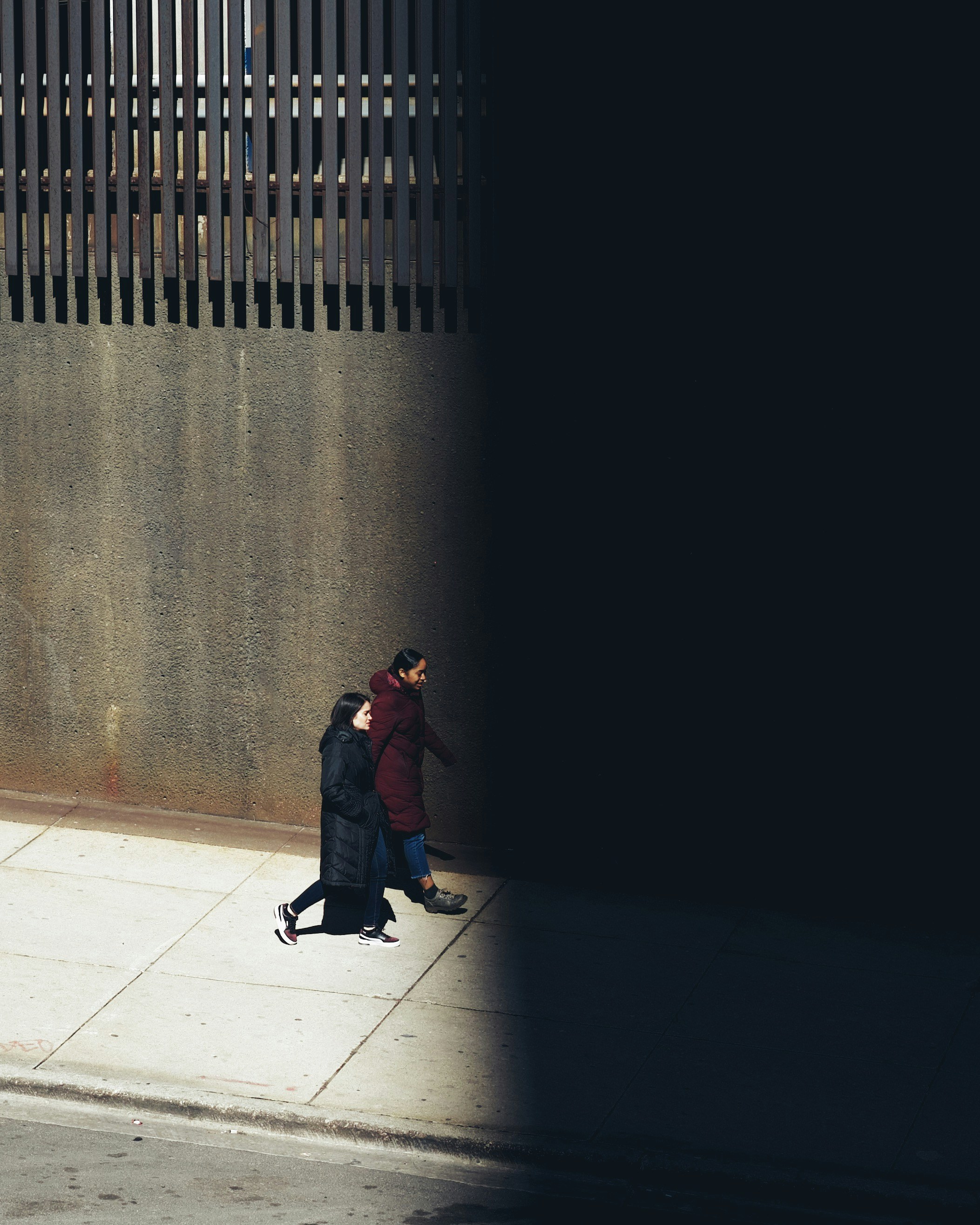 woman in black coat standing on white floor tiles