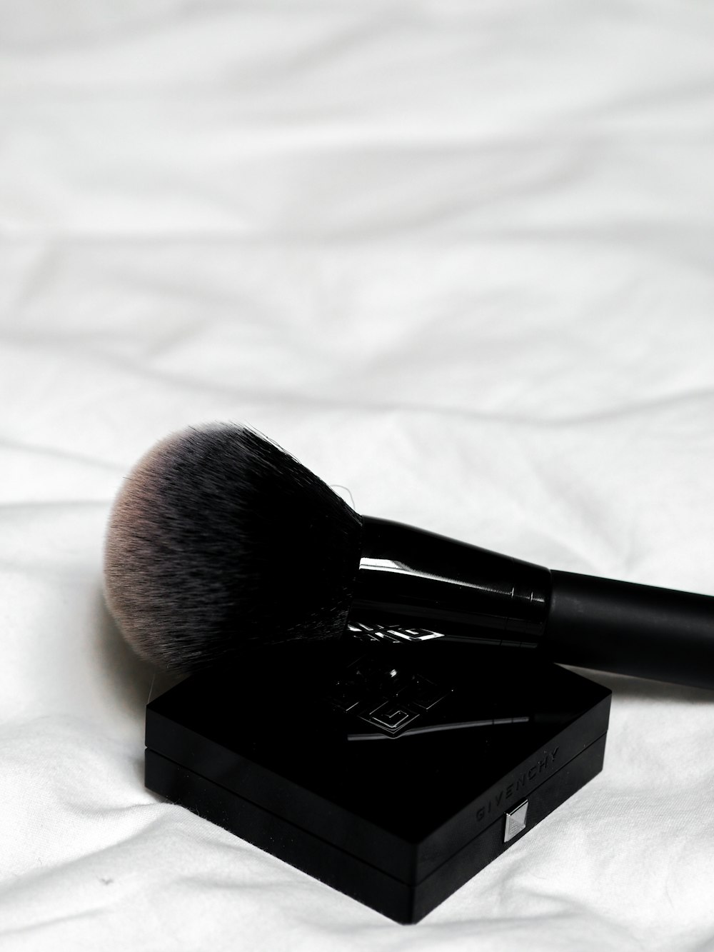 black make up brush on white textile