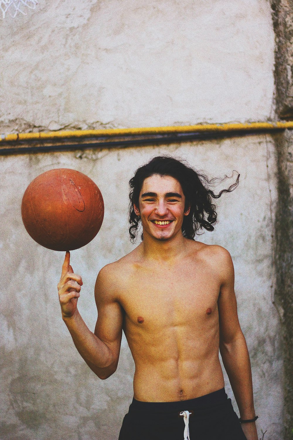 topless man holding red ball