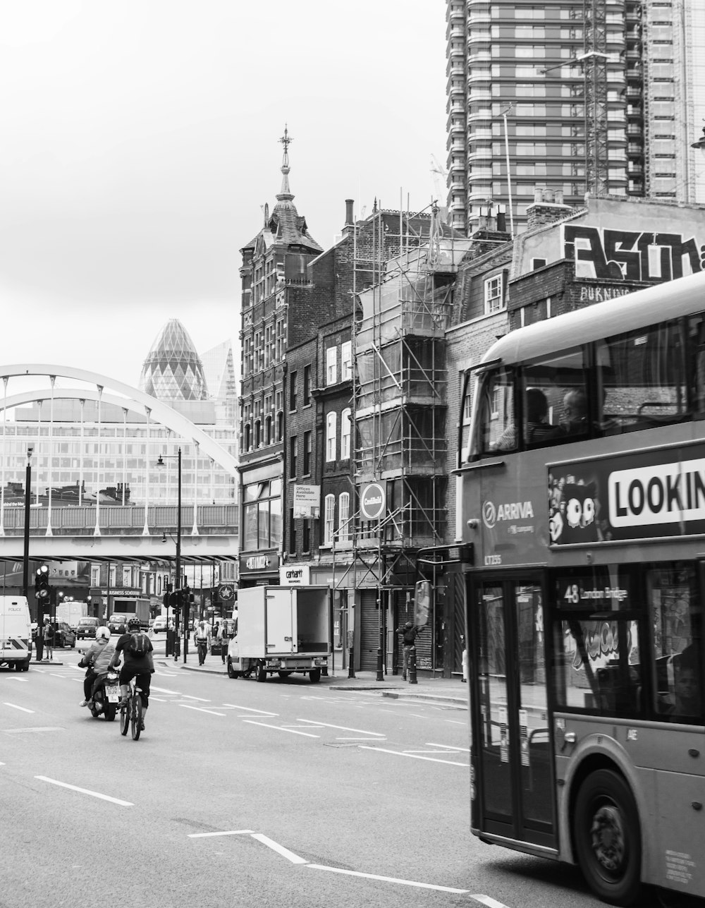 grayscale photo of people walking on street near building