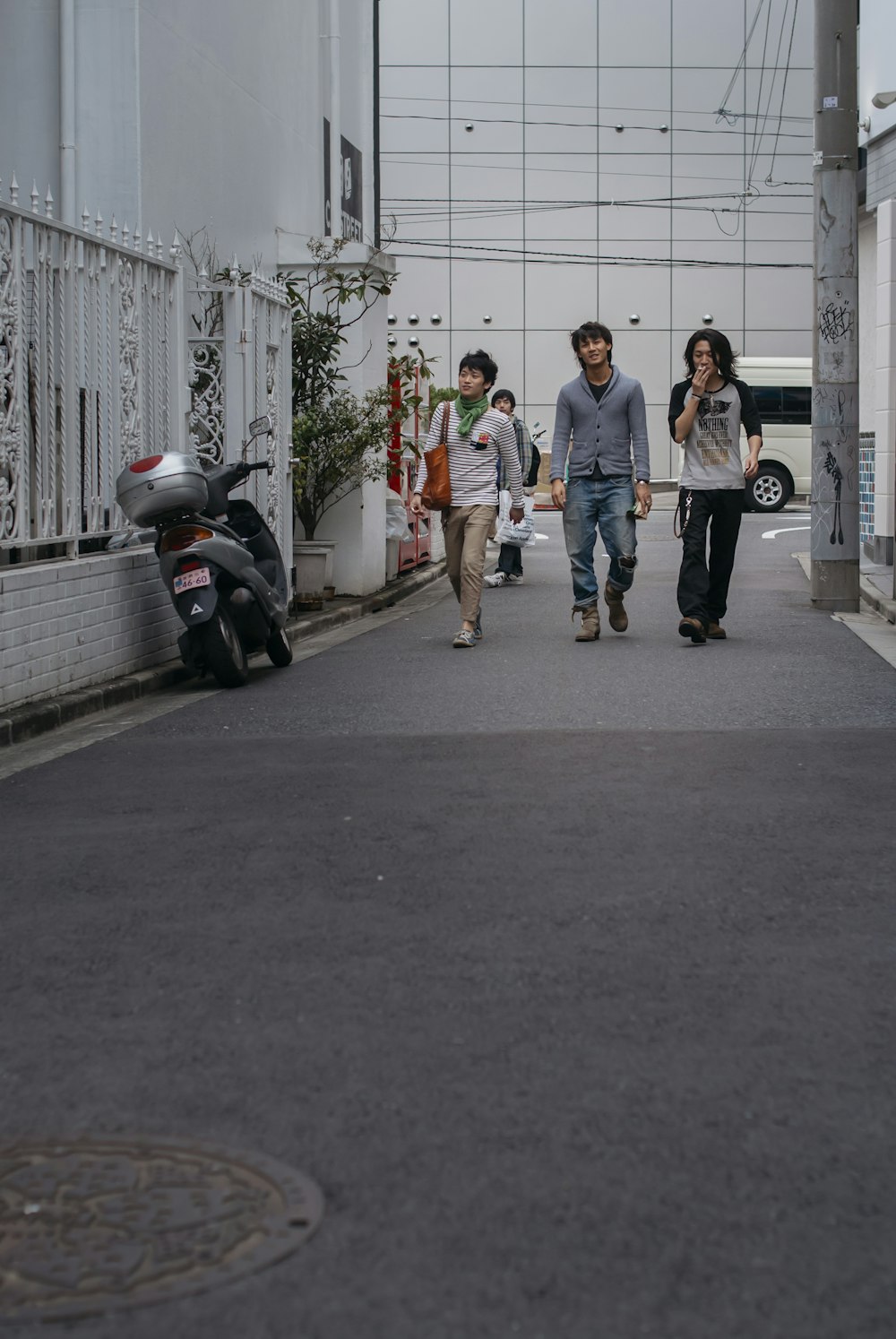 青いドレスシャツを着た男性と白いTシャツを着た女性が昼間に歩道を歩く