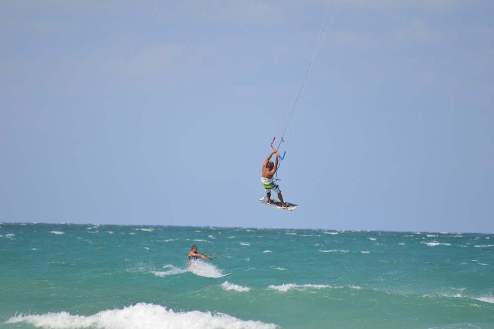 man in black shorts surfing on sea during daytime