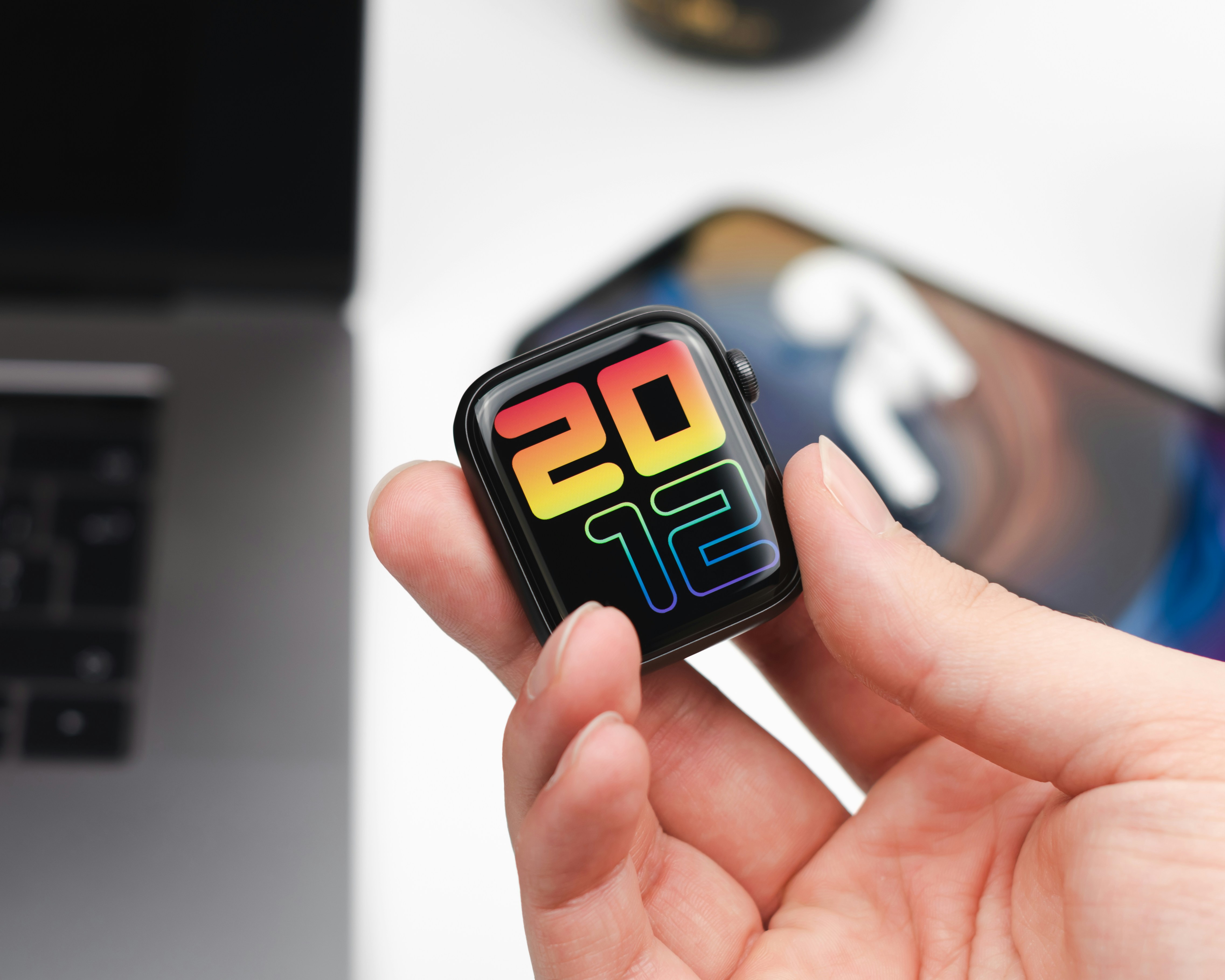 persona sosteniendo un teléfono inteligente blanco y negro