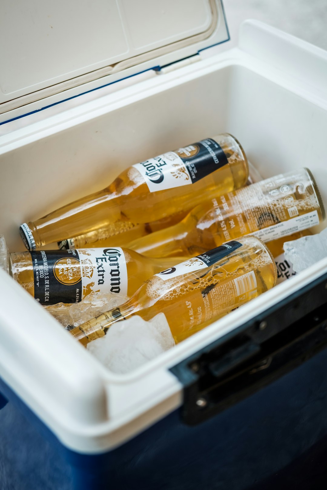  yellow labeled bottle in white plastic container cooler