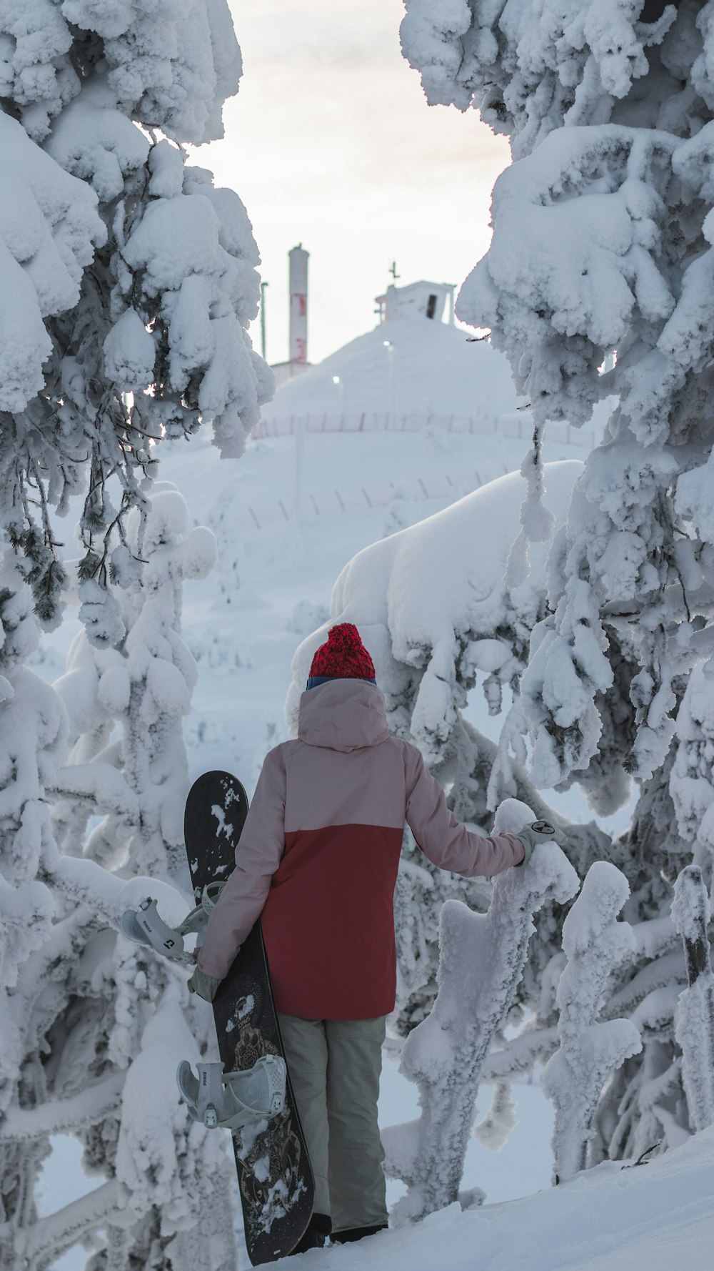 person in red hoodie standing on snow covered ground during daytime