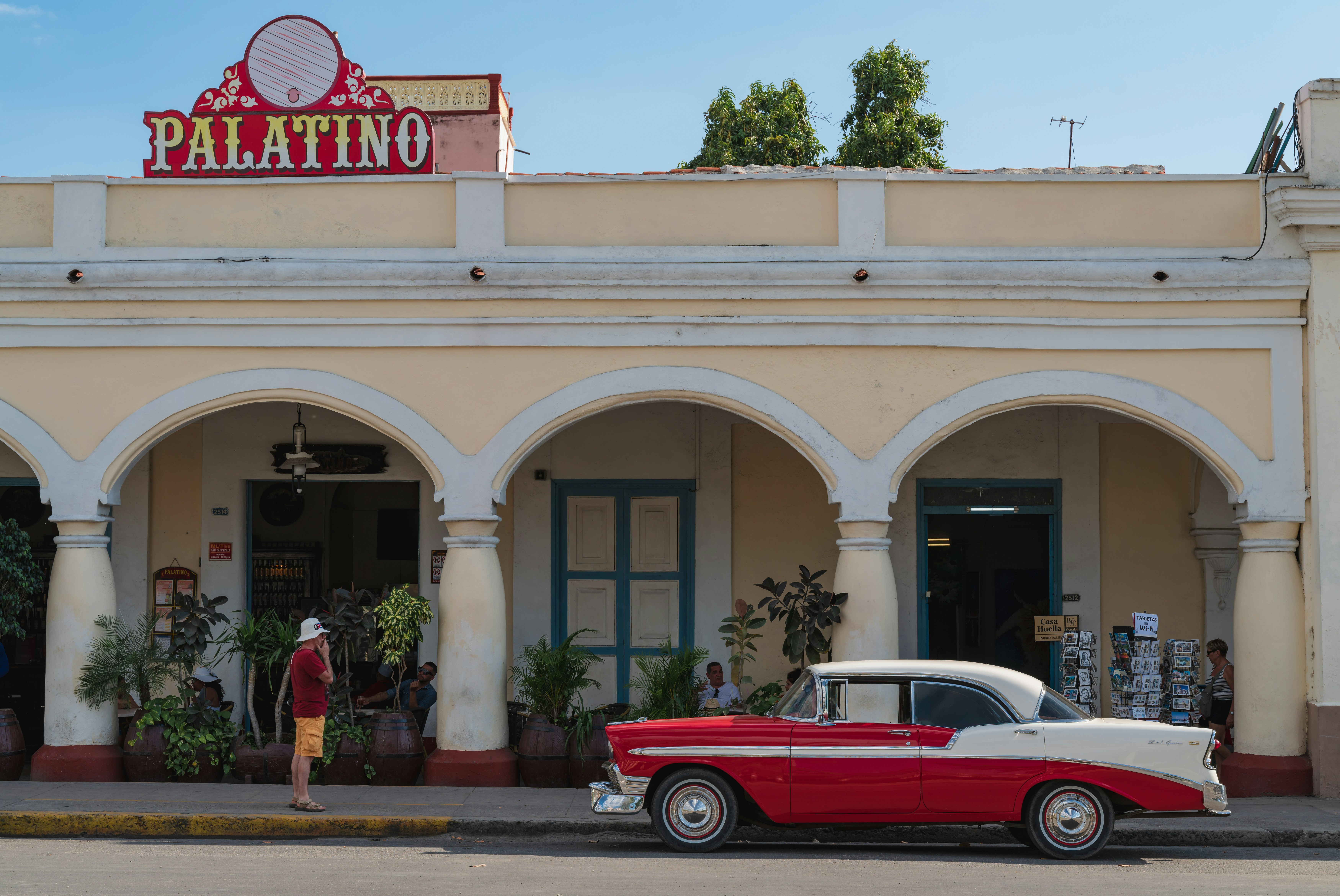 red convertible car parked in front of white and brown concrete building during daytime