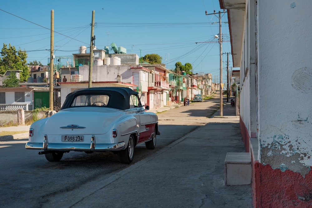 blue classic car parked on sidewalk during daytime