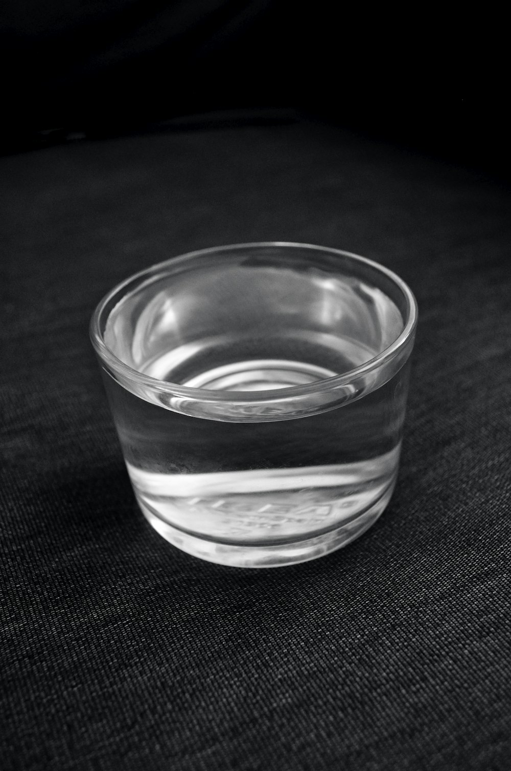 Bicchiere trasparente su tessuto nero