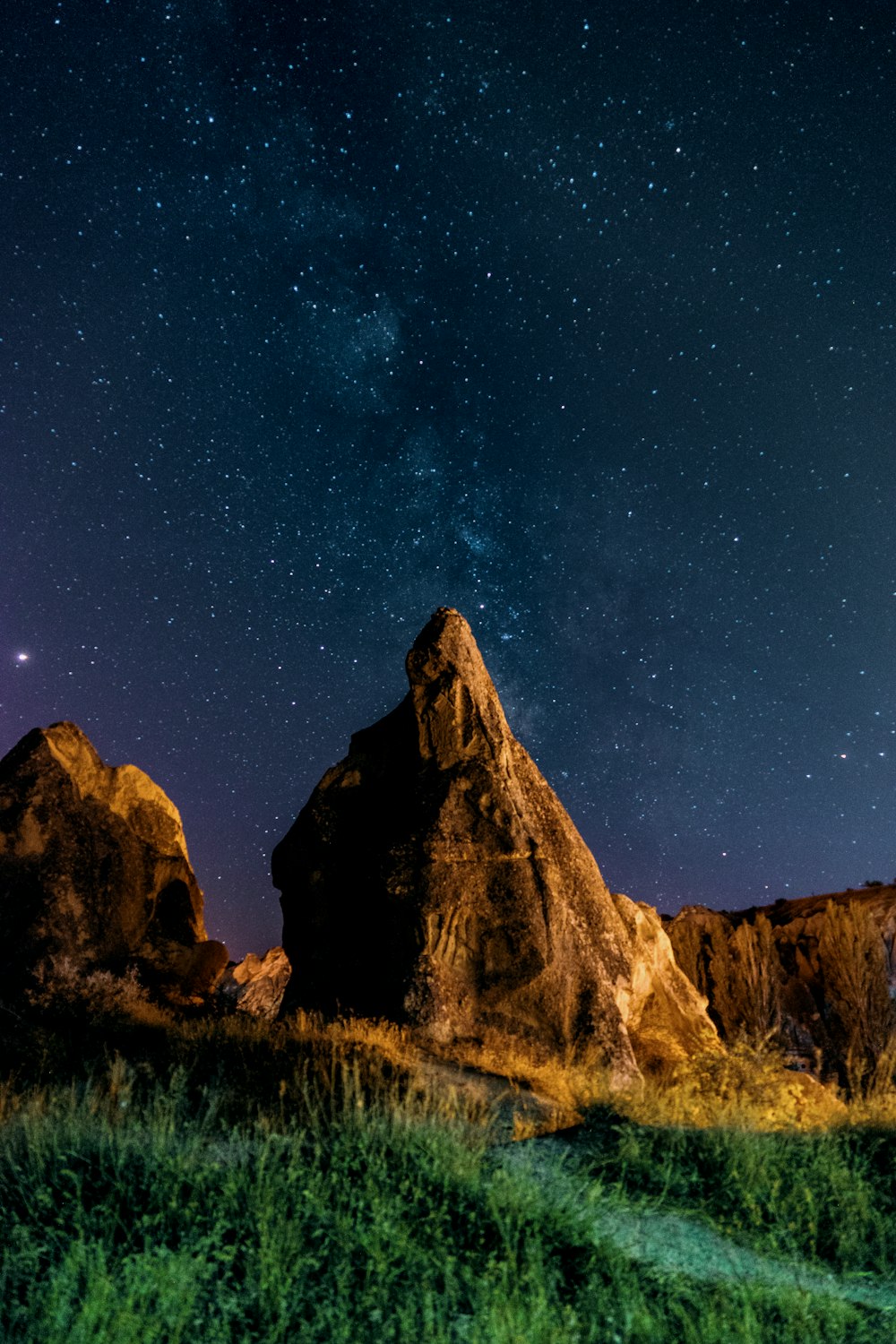 brown rock formation under starry night