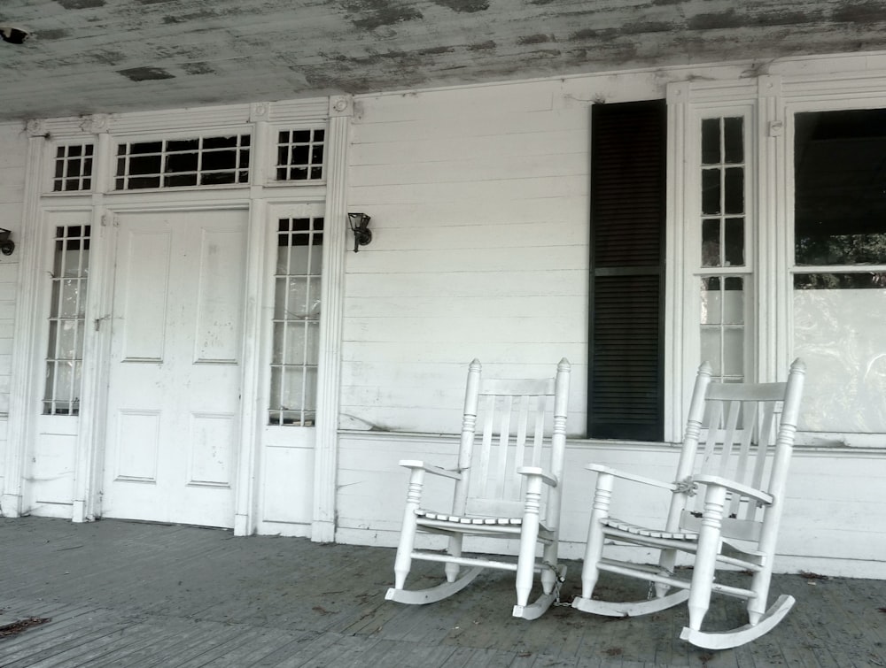 white wooden rocking chair beside white wooden door