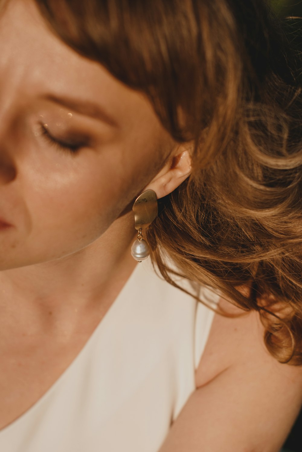 woman wearing silver and white pearl stud earring