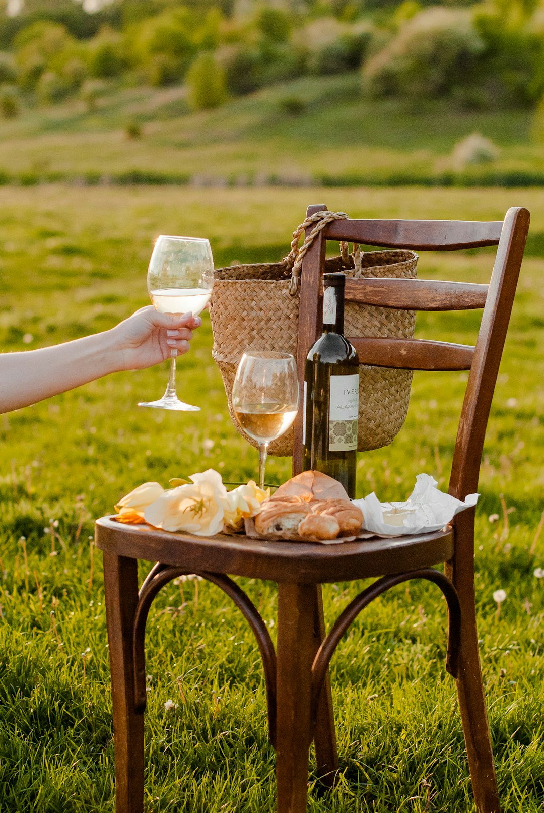 person pouring wine on clear drinking glass