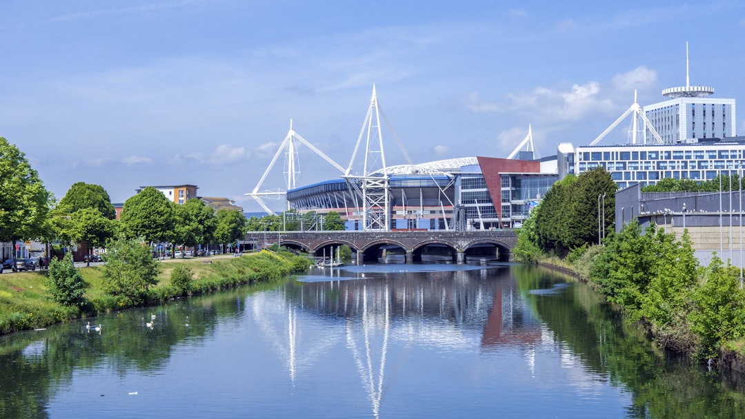 a river running through a city next to tall buildings, Photo of a Principality Stadium in Cardiff overlooking River Taff