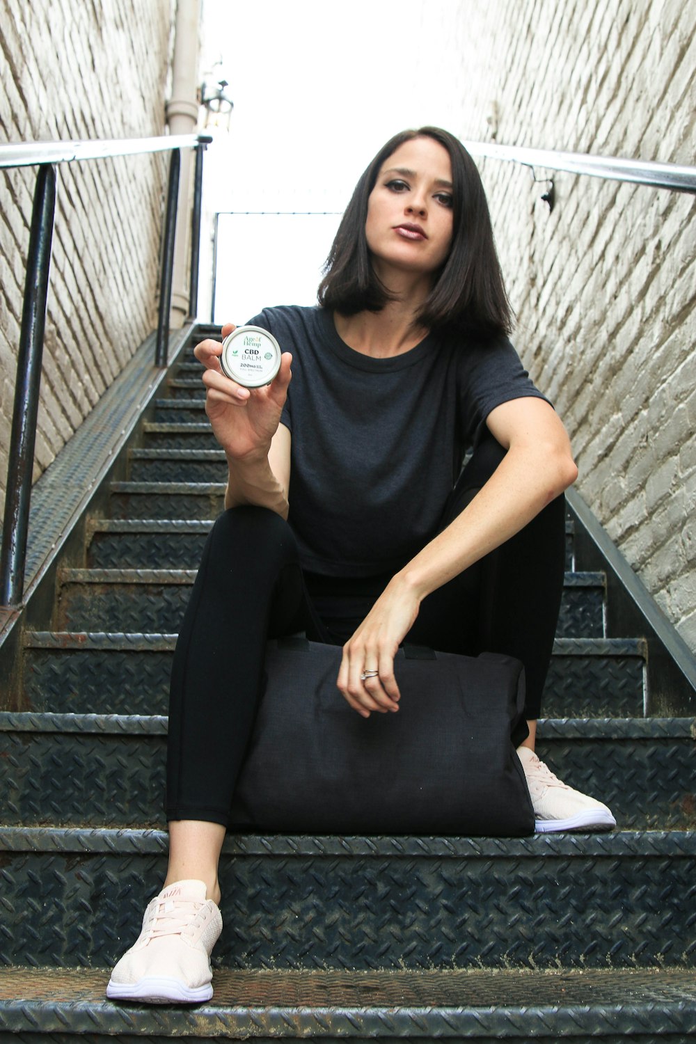 woman in black crew neck t-shirt and black pants sitting on stairs