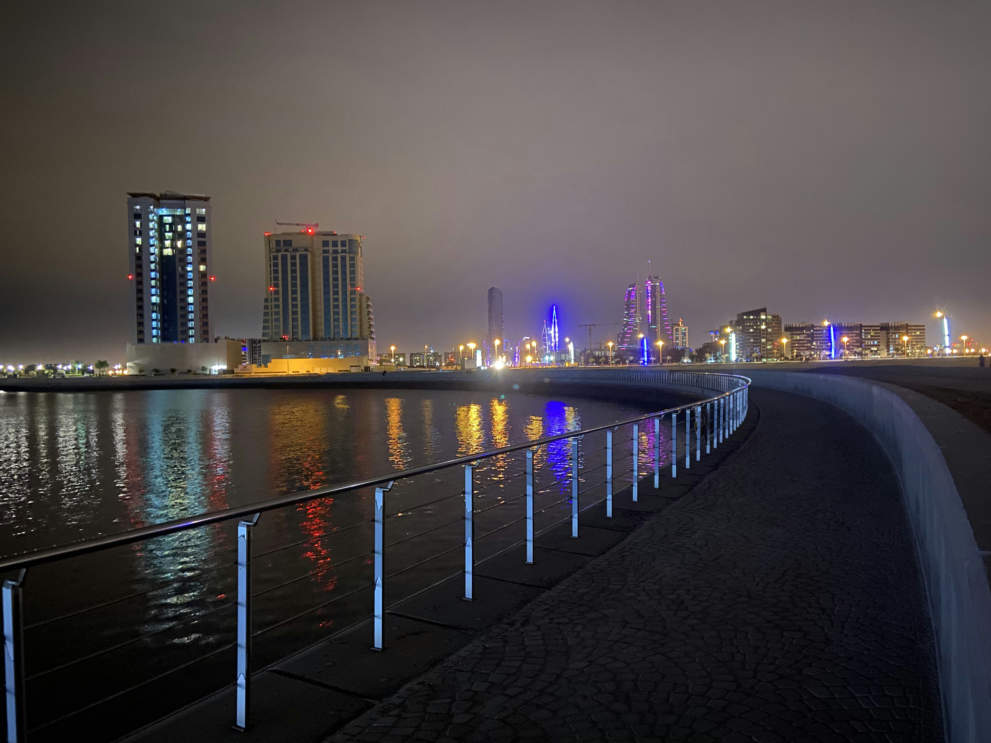 city skyline across body of water during night time
