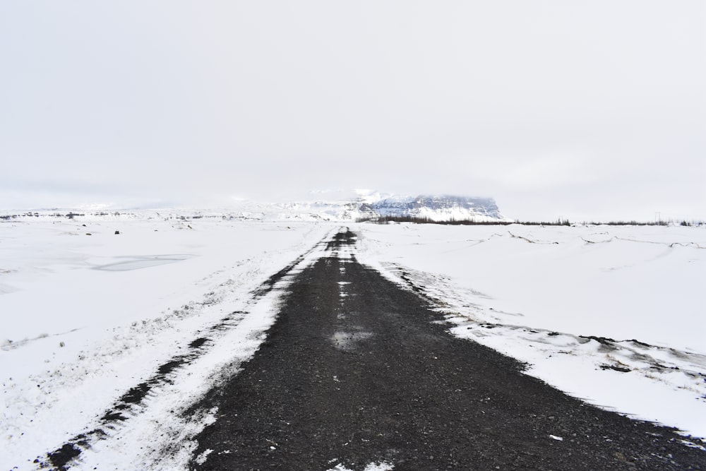 black asphalt road covered with snow