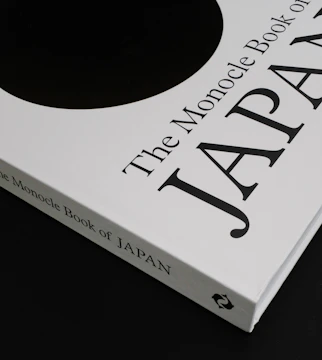Elegant cover mockup of the Japanese language survival guide featuring minimal design in navy and burgundy tones