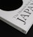 A close-up of a book titled 'The Monocle Book of Japan' with a sleek black and white cover. The book is positioned on a dark surface, creating a contrast with its white cover that features bold black text and a minimalist design.