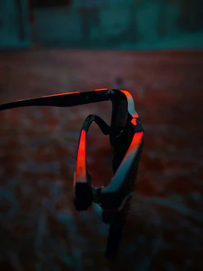 High-end designer sunglasses with bold red frames and gradient lenses under soft lighting.