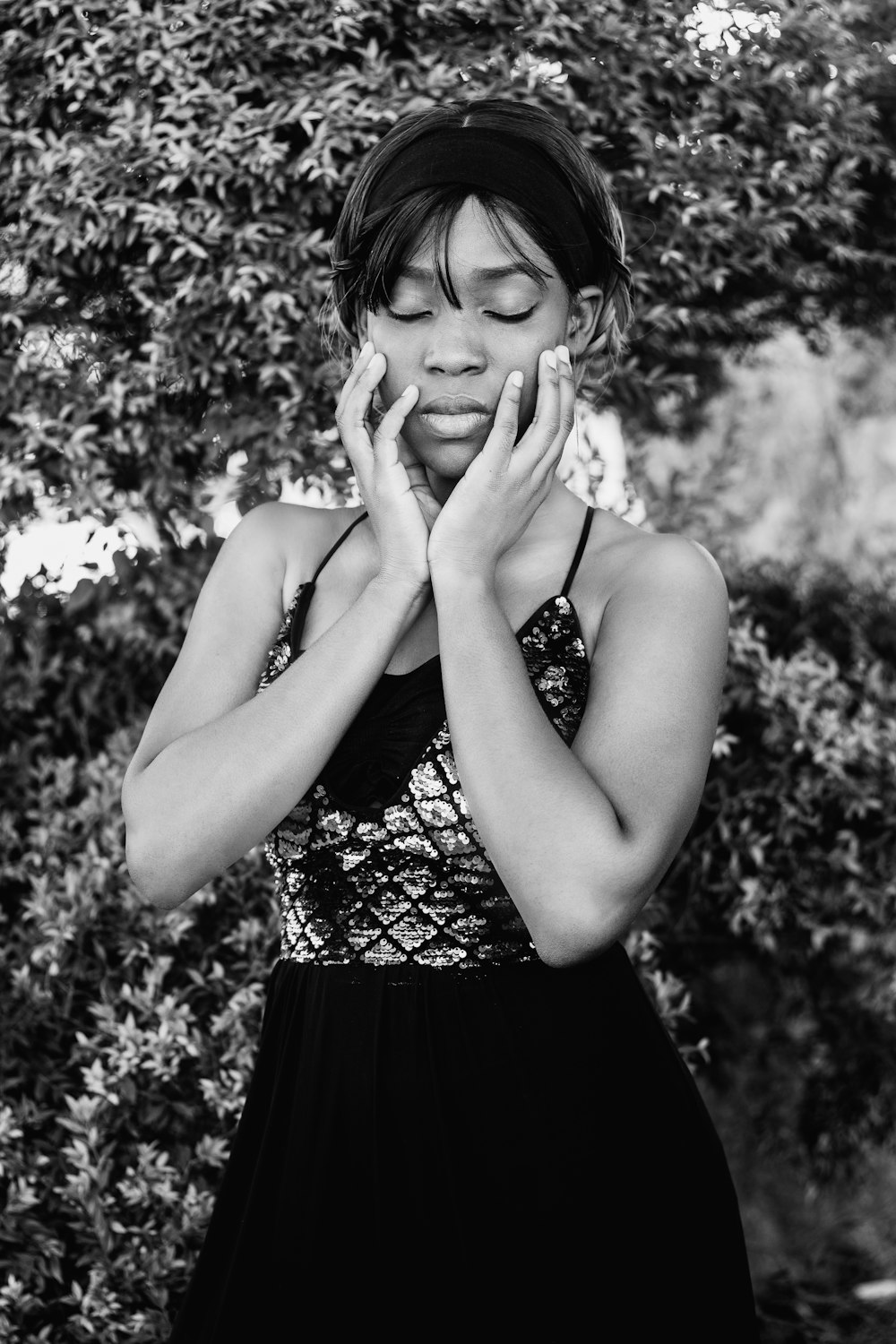 woman in black and white tank top covering her face with her hand