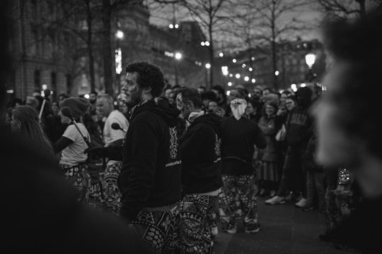 Crowds enjoying the downtown Art Walk with street art displays and musicians performing in the evening.