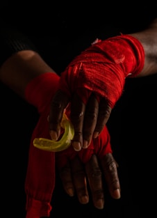  a boxers hands in hand wraps holding a gumsheild