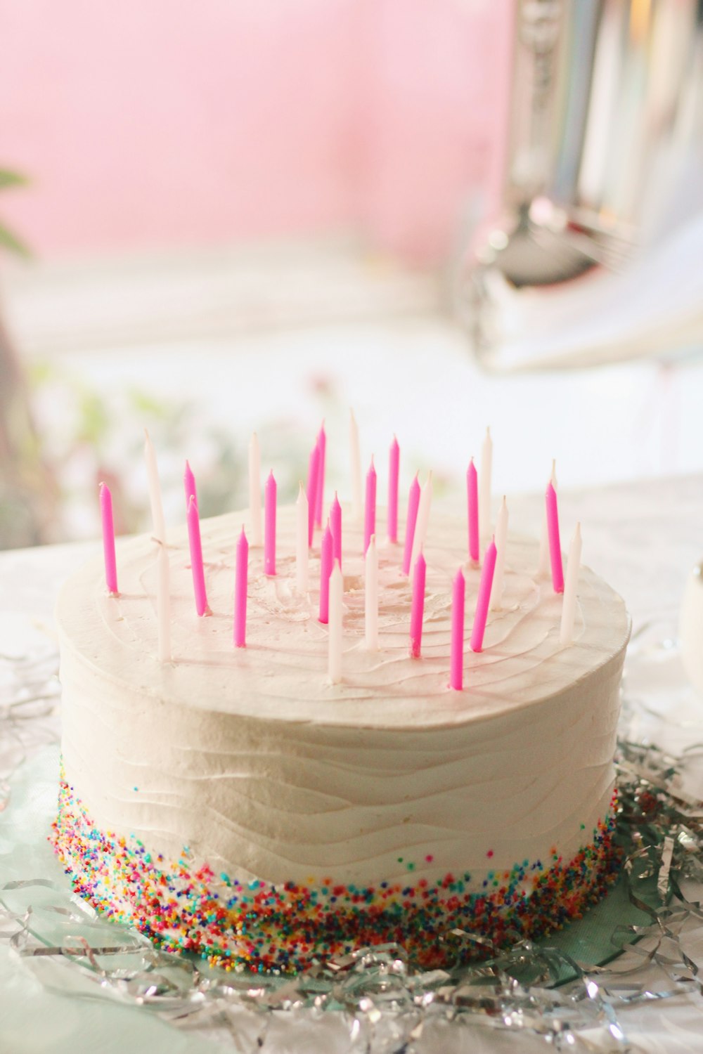 pink and white cake with candles
