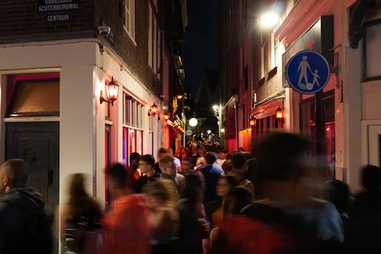 people walking on street during nighttime in De Wallen Netherlands