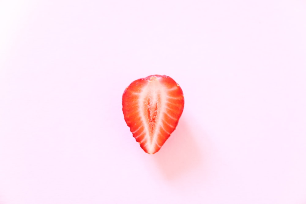 sliced strawberry on white surface